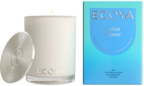 Een witte kaars met metalen deksel en blauwe doos met 'ECOYA Lotus Flower' label in eenvoudige ontwerp.