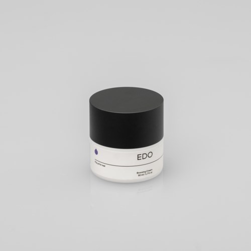 Kleine witte container met zwarte deksel met de tekst "EDO". Minimalistisch ontwerp, waarschijnlijk een cosmetica- of huidverzorgingsproduct.