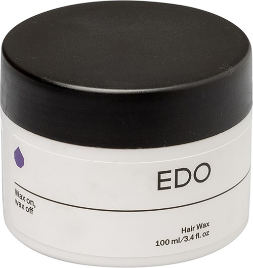 Een witte pot haarwax met een zwarte deksel, gelabeld 'EDO' en 'Wax on, wax off' in kleine tekst.