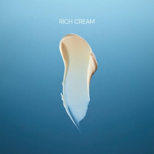 A dollop of cream with a gradient from white to blue on a blue background, labeled Rich Cream.