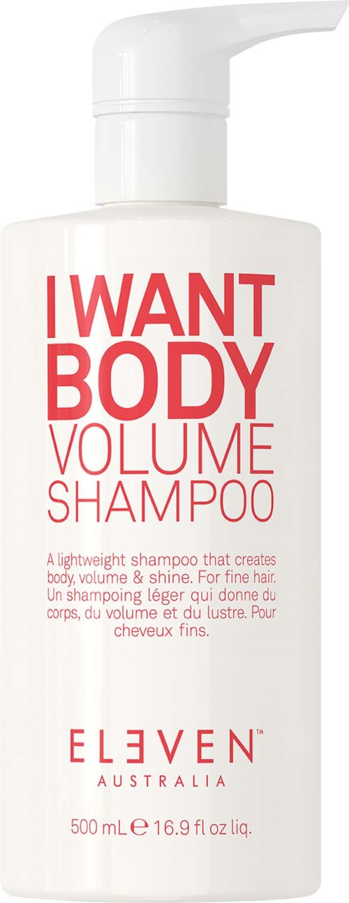 A white bottle of I WANT BODY volume shampoo with a pump and red and pink text on it.