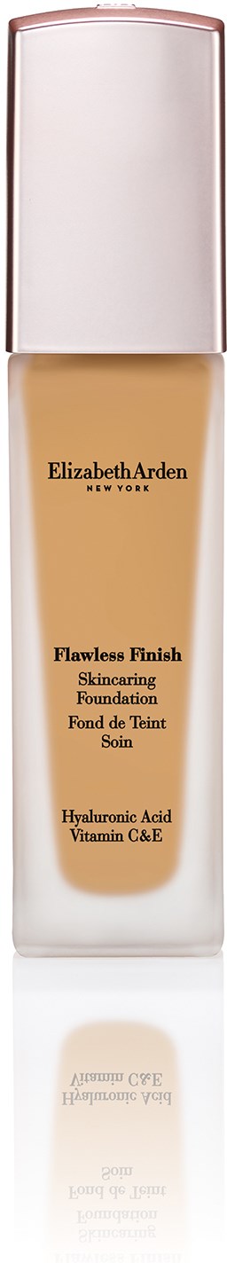 En lang flaske med hvit lokk som inneholder Elizabeth Arden foundation, merket som Flawless Finish med hyaluronsyre og vitamin C&E.