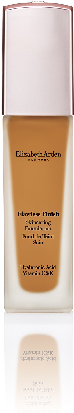 En høy, klar flaske med hvit lokk som inneholder flytende foundation. Merket er Elizabeth Arden Flawless Finish med hudpleiefunksjoner.