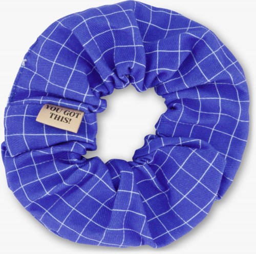 A blue fabric scrunchie with white grid lines and a small beige tag that says "YOU GOT THIS!".
