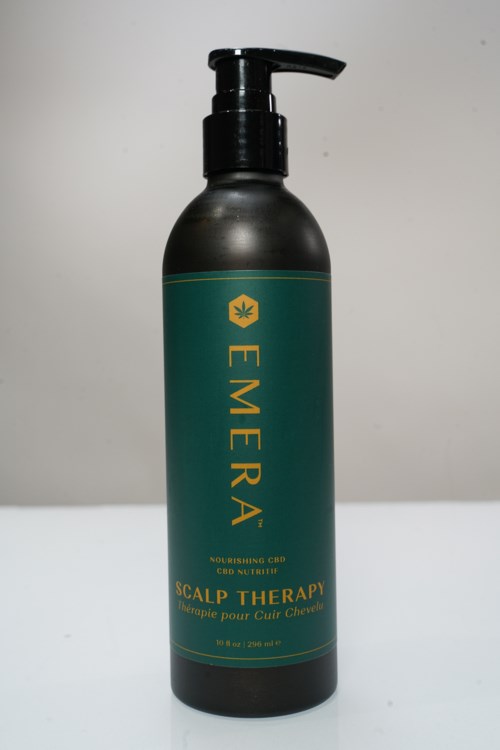 En svart flaska med pump och grönt märke, som heter EMERA, för hårbottenbehandling med CBD, 8 fl oz och 236 ml.