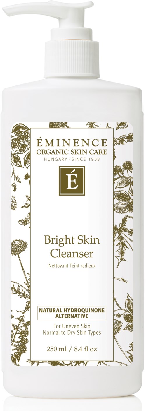 Een witte fles met pomp, label 'Eminence Bright Skin Cleanser,' met gouden en plantillustraties.