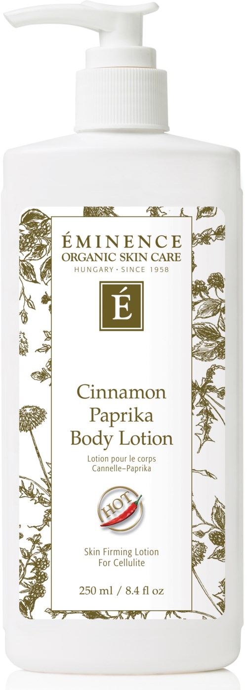 A white bottle with a pump, labels with gold and green leaves, and text about cinnamon body lotion.