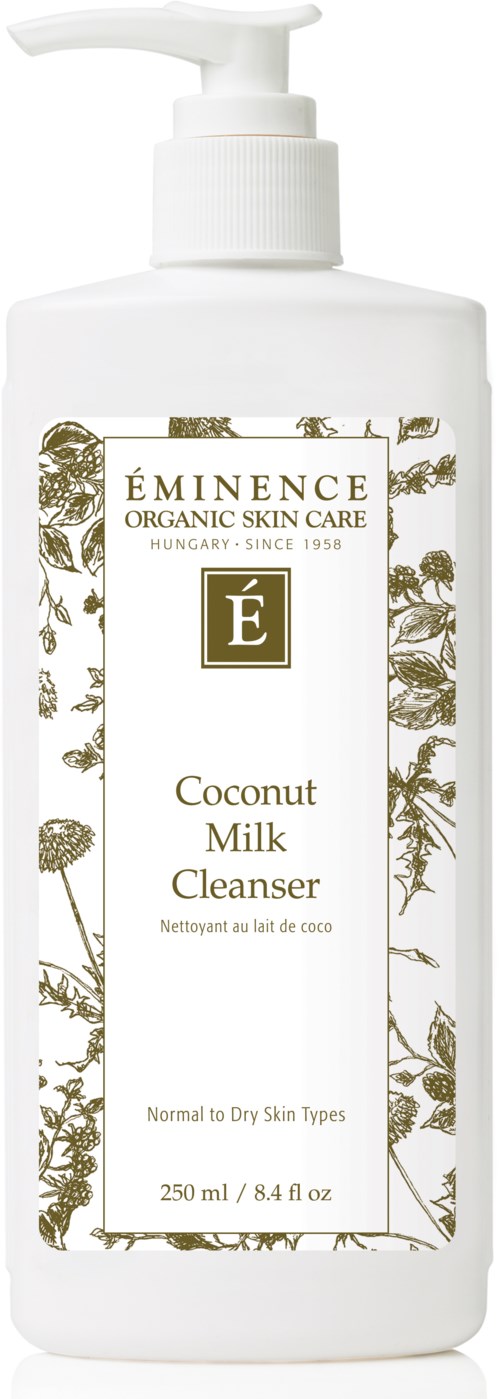 En hvit flaske med pumpe, etiketten sier 'ÉMINECE Coconut Milk Cleanser,' for normal til tørr hud, 250 ml.