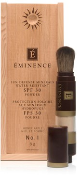 En låda och en borste av Éminence solpuder med SPF 30 och naturliga ingredienser, för ansiktsskydd.