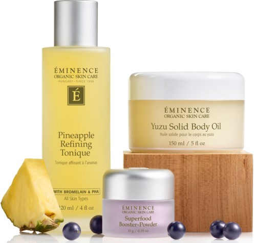 Skincare products with pineapple scent, including toner, body oil, and booster powder, along with pineapple and berries.