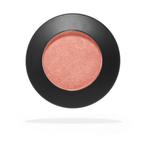 A round blush makeup compact with a peachy pink color, housed in a black case.