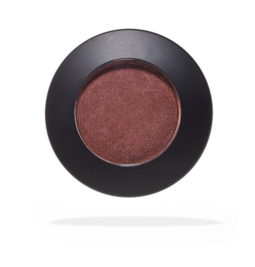 A round makeup blush in a black container with warm pinkish hue. Looks smooth and slightly shimmery.