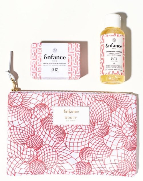 En rosa och vit necessär, en rosa tvålkub och en gul schampofläsk. Necessären och tvålboxen har geometriska mönster.