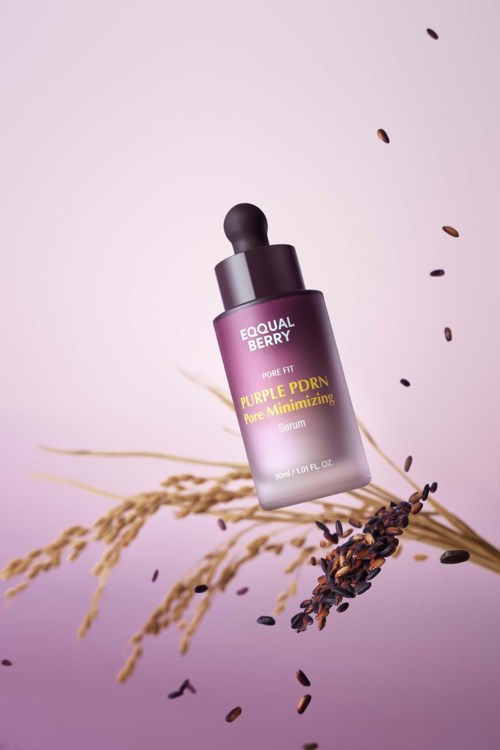 En lilla hudpleieflaske merket 'Equal Berry Purple PDRN' med planter og frø rundt den.