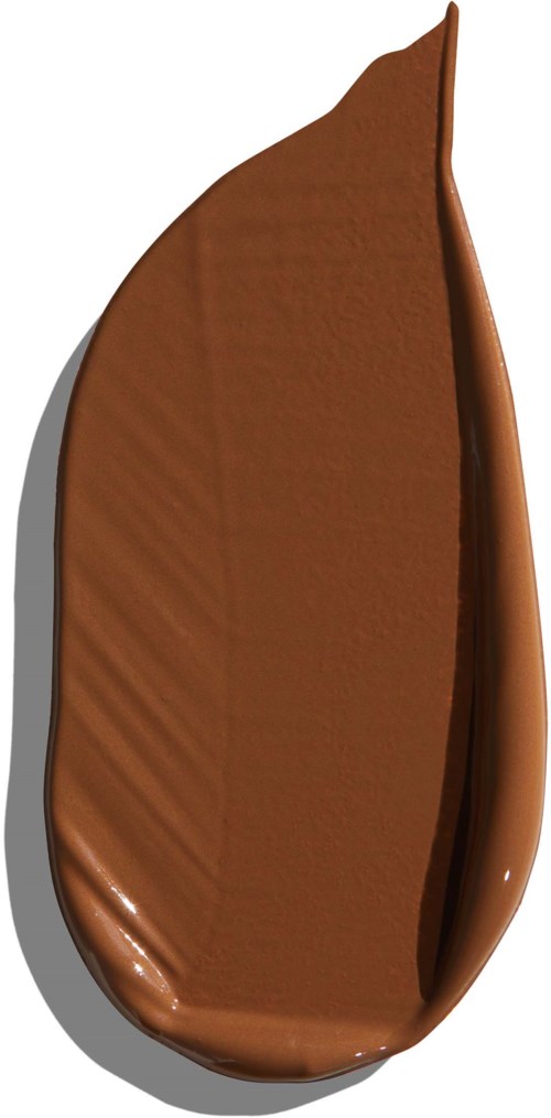 En skeformet genstand dækket af glat, skinnende mælkechokolade med en buet kant.