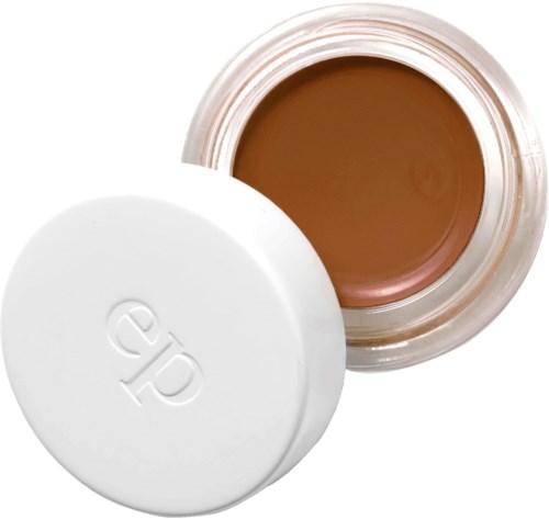En lille glas med beige creme indeni og et hvidt låg. Låget har en logo på.