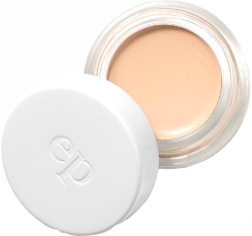 En beholder med beige creme med en hvid låg ved siden af, der viser det åbne produkt.