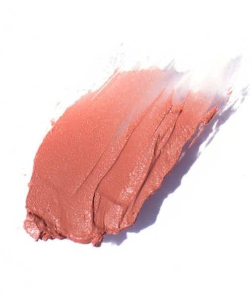En smet av persikorfärgad makeup eller kräm på en vit yta.