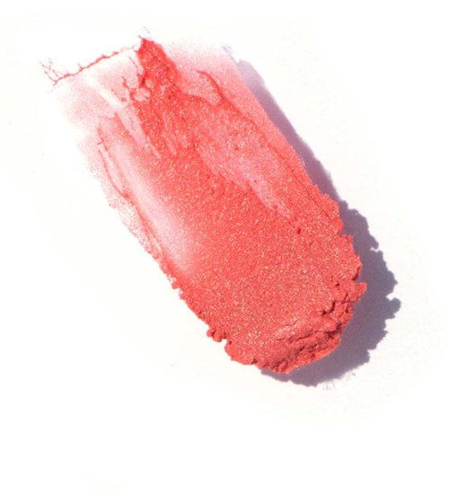 En röd makeup- eller blushsmetning utsmetad på vitt papper med skugga, visar textur och färg.