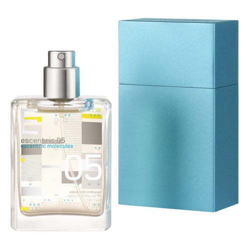 A clear spray bottle labeled 'escentric 05' next to a blue box. The bottle has a silver spray top.