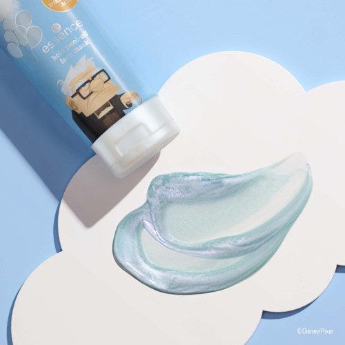 A blue lotion tube and a doll character stand above a smear of shiny, light-colored cream on a cloud-shaped surface.