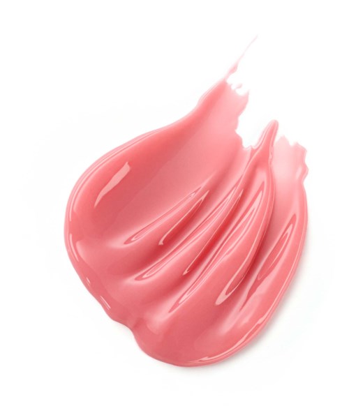 Ett streck av rosa läppstift med glansig yta, lätt utbrett på vit bakgrund.