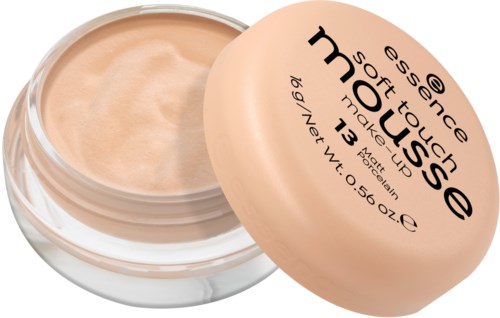 Ein kleiner, runder Behälter mit beige weicher Make-up und einem pfirsichfarbenen Deckel mit Produktdetails. Der Deckel ist teilweise offen.