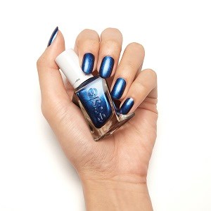 Eine Hand zeigt Nägel mit glänzend blauem Nagellack, die eine Flasche des gleichen Nagellacks hält.