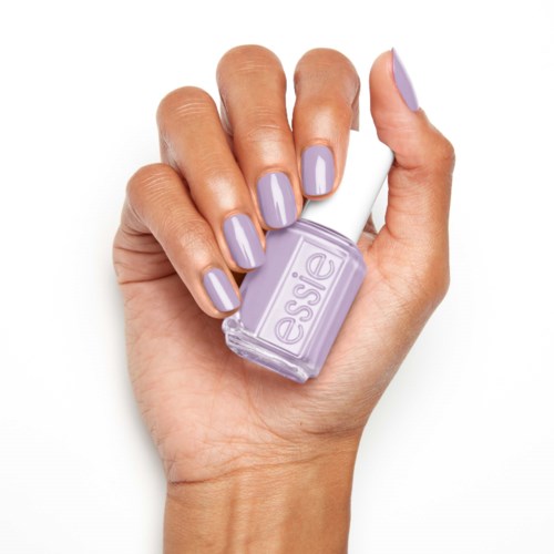 Kädessä on violettisin kynsinauhoin maalaillut kynnet, ja se pitää pienen, läpinäkyvän essie-lakan pulloa.