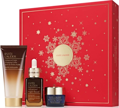 Set van Estee Lauder huidverzorgingsproducten voor nachtherstel in een rode feestdoos met sneeuwvlokontwerp.