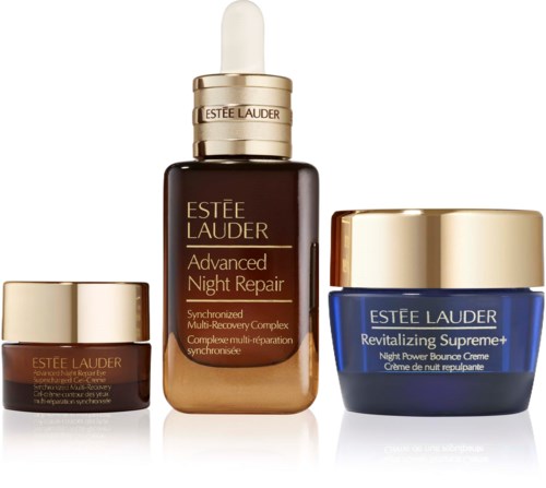 Tre Estée Lauder hudvårdsprodukter med guldlock, inklusive en nattfixeringsserum, en kräm i blå burk och en liten ögonsalva.