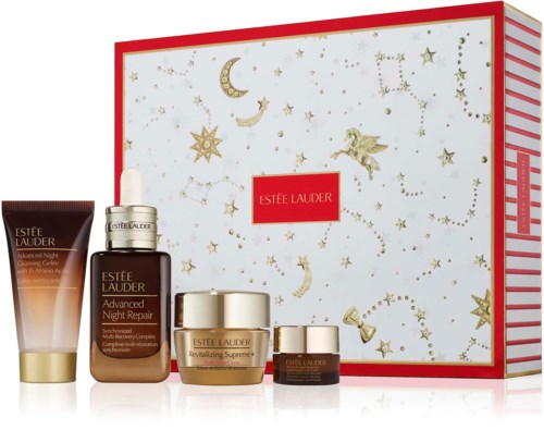 En hudvårdsuppsättning med fem Estée Lauder-produkter framför en festlig, stjärnmärkt presentlåda.