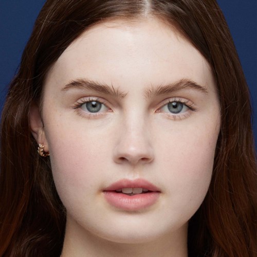 Young woman with long brown hair and blue eyes, looking straight at the camera with a neutral expression.