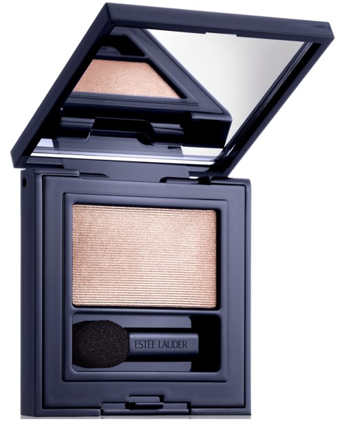 A beige eyeshadow in a black compact with a mirror and a small applicator brush.