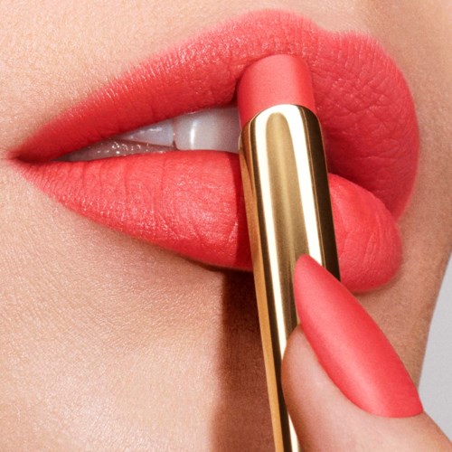 Iemand brengt roze lippenstift aan met een tube, lippen licht gespreid en tonen tanden, huid glad.