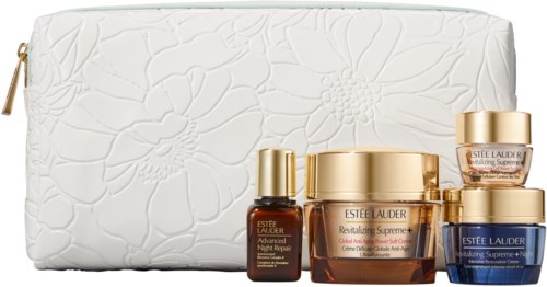 Ett hudvårdspaket med krämer och serum i små burkar och flaskor, med en vit embossed blomstersäck.