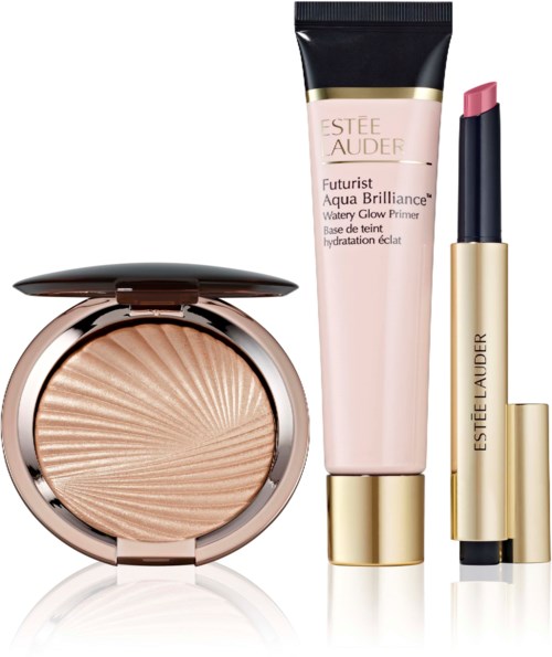 Ein Kompaktpuder, eine rosa Foundationtube und ein rosa Lippenstift mit Goldakzenten von Estée Lauder.
