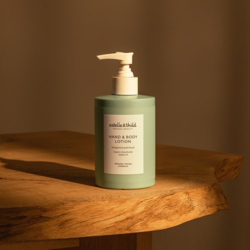 Vihreä voidepullo, jossa pumppu, etiketti lukee 'Estelle & Thild Hand & Body Lotion.'