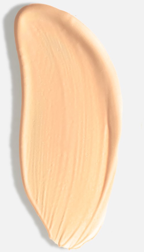 A peach-colored cream or lotion is spread on a white surface, creating a smooth, curved shape.