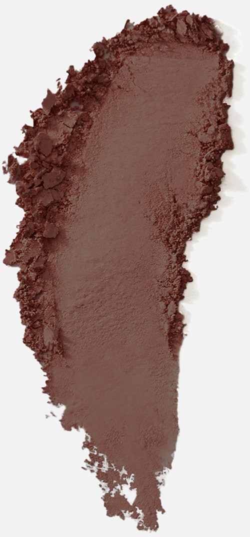 En stor fläck av brun makeup eller puder på en ljus bakgrund, ojämna kanter, med en mörk remsa på vänster sida.