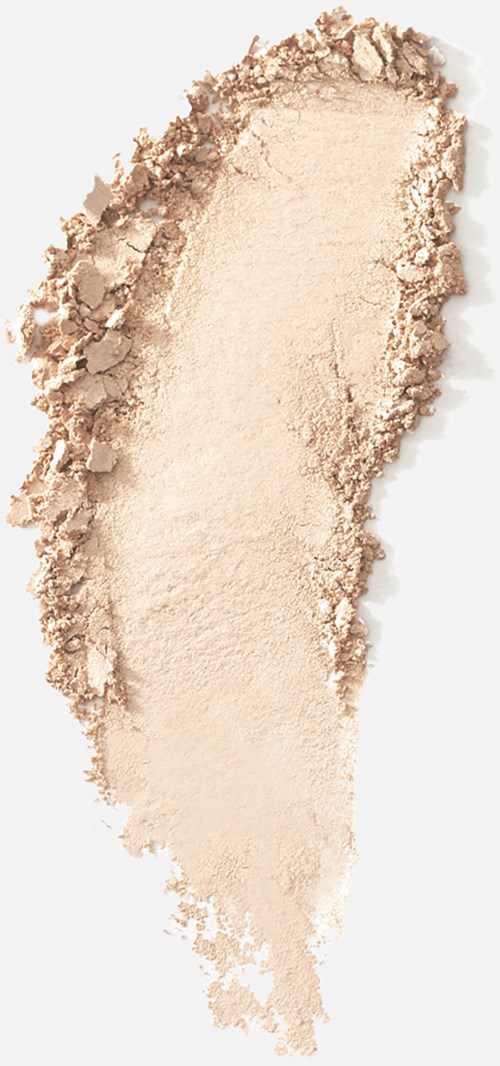 Ljus beige pulver utspritt ojämnt på en vit bakgrund, med vissa områden skrapade eller texturerade.