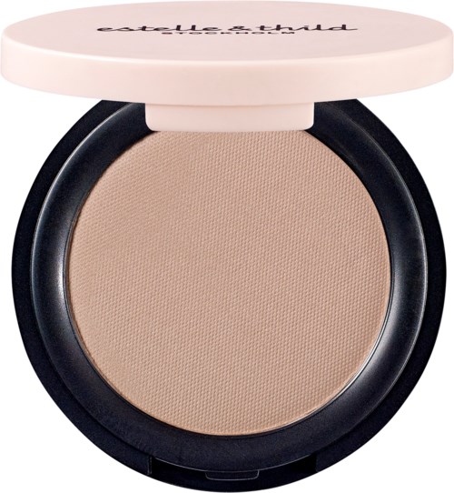 En compact med beige puder och ett vitt lock med svart text. Det används för smink.