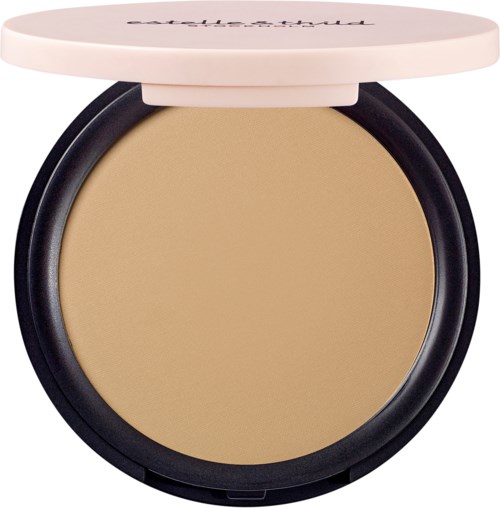 A compact with beige powder and a white lid. The lid has handwritten text on it.