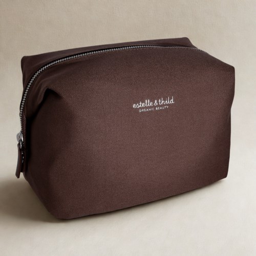 En brun kosmetikkveske med glidelås, merket 'estelle & thild ORGANIC BEAUTY' i hvitt tekst.