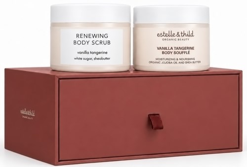Twee potten lichaamscrème en lichaamssoufflé op een rode lade, etiketten lezen vanille mandarijn geur. "Renewing Body Scrub" en "Estelle & Thild."