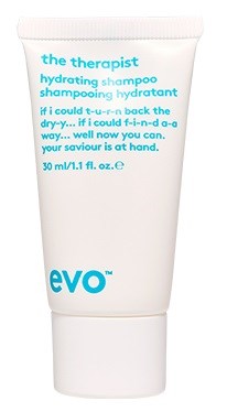 A white tube labeled 'evō' contains hydrating shampoo with blue text promoting its benefits and usage.