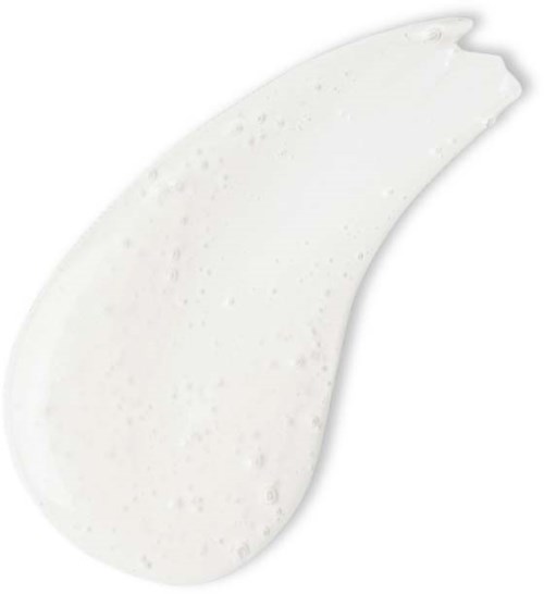 A white cream with small speckles, thick and spread out, on a clean surface.
