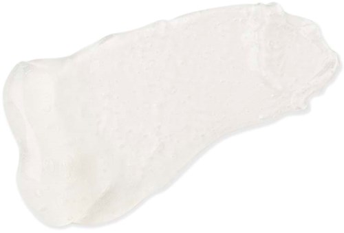 A white, irregularly shaped smear of cream or lotion on a plain background.