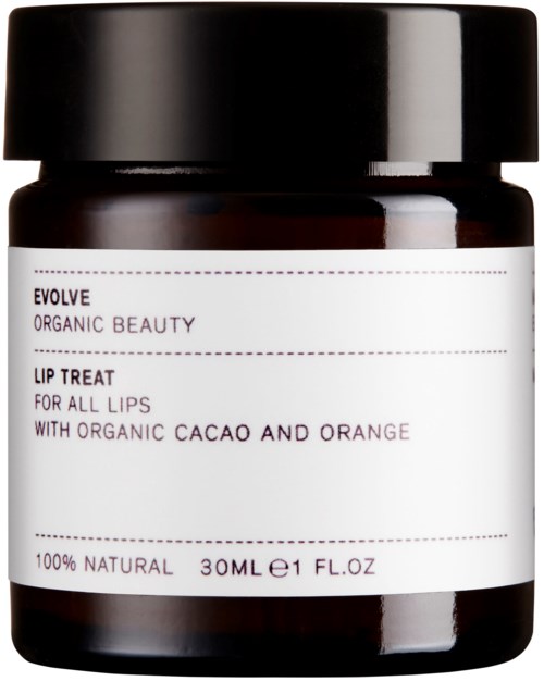 A small dark jar with a white label, black lid, containing lip treat with cacao and orange.