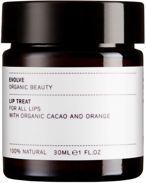 En mørk krukke med hvit etikett som sier "Evolve Organic Beauty Lip Treat" med naturlige ingredienser som kakao og appelsin.